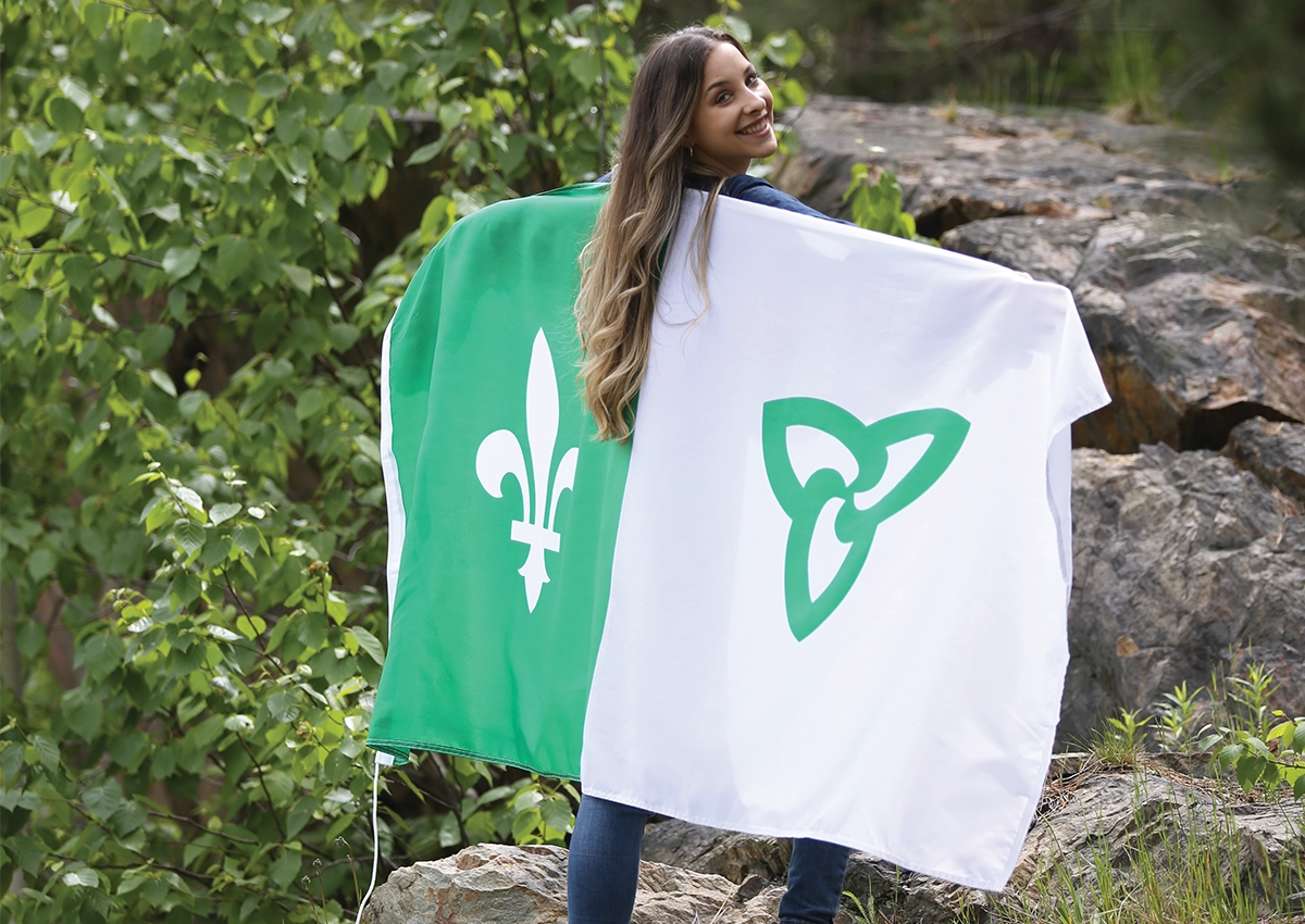 A francophone student at Laurentian University wearing a franco-ontarian flag on her back.