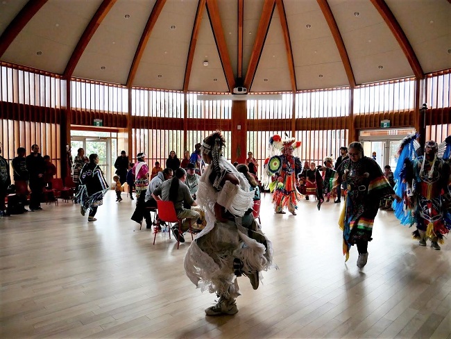 Round Room Dance in the Indigenous Sharing and Learning Centre; Dome shaped architecture with dancers in their regalia.
