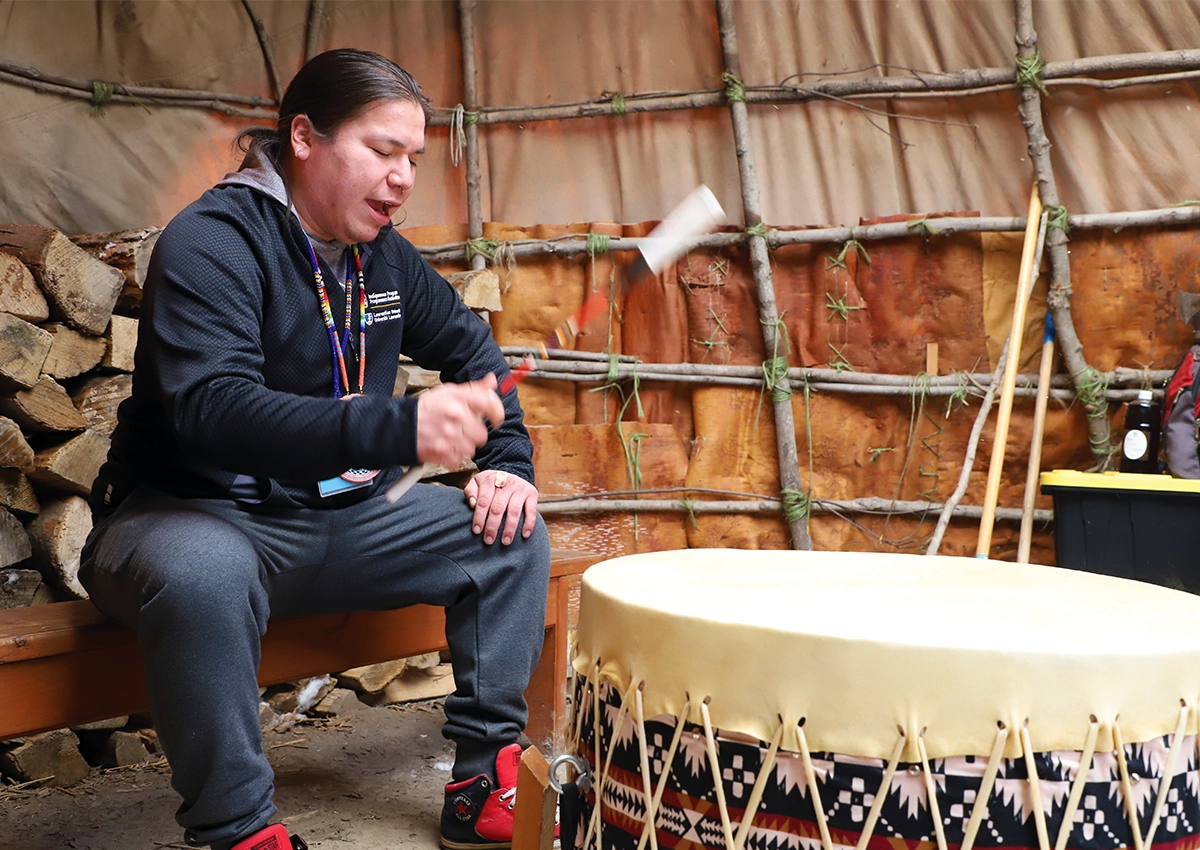 An Indigenous Laurentian University staff member drumming.